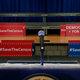 Signs sit behind the podium before the start of a press conference April 3, 2018, with the then New York attorney general Eric to announce a multistate lawsuit to block the Trump administration from adding a question about citizenship to the 2020 census form.